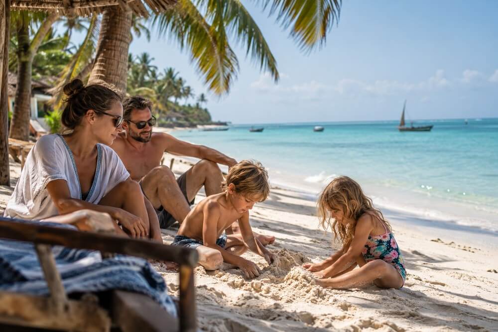 Rodzina odpoczywająca na plaży Zanzibaru podczas ferii zimowych